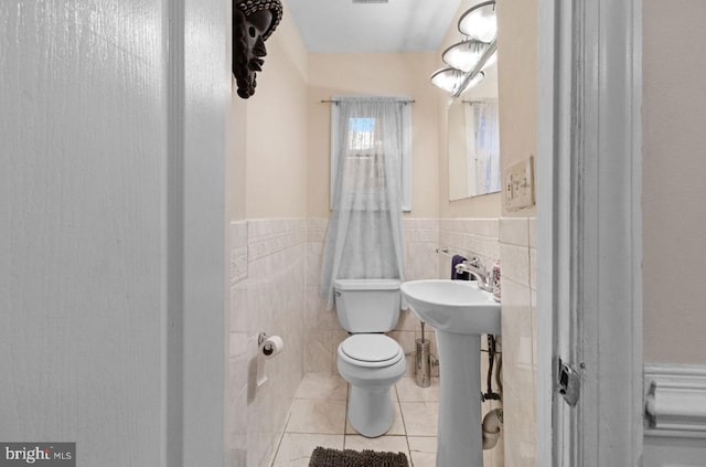 bathroom with sink, tile walls, tile patterned floors, and toilet