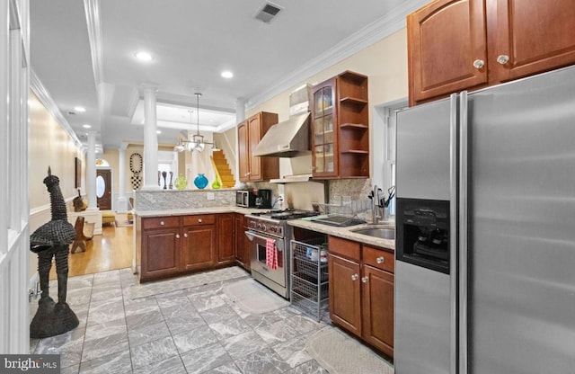 kitchen featuring an inviting chandelier, stainless steel appliances, hanging light fixtures, wall chimney range hood, and crown molding