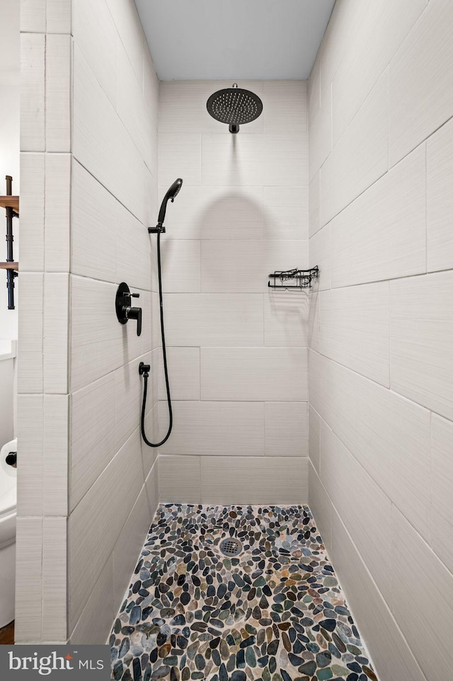 bathroom with tiled shower and toilet