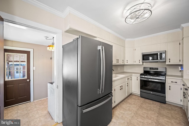 kitchen featuring sink, white cabinets, stainless steel appliances, and ornamental molding