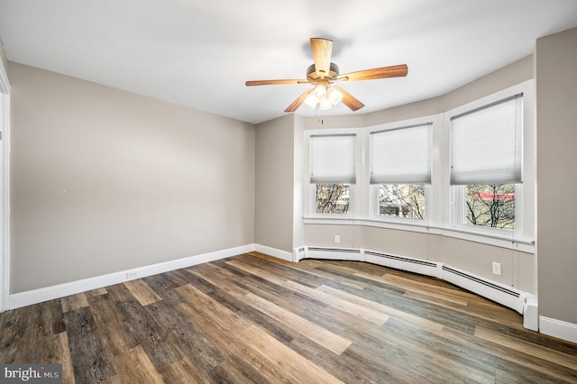 empty room with dark hardwood / wood-style flooring, a baseboard radiator, and ceiling fan