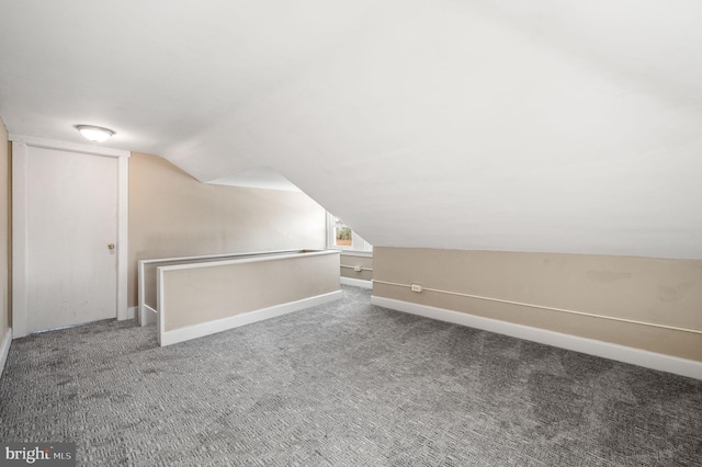 additional living space featuring carpet flooring and vaulted ceiling