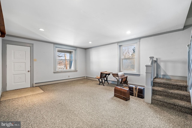 sitting room featuring carpet flooring, crown molding, and a healthy amount of sunlight