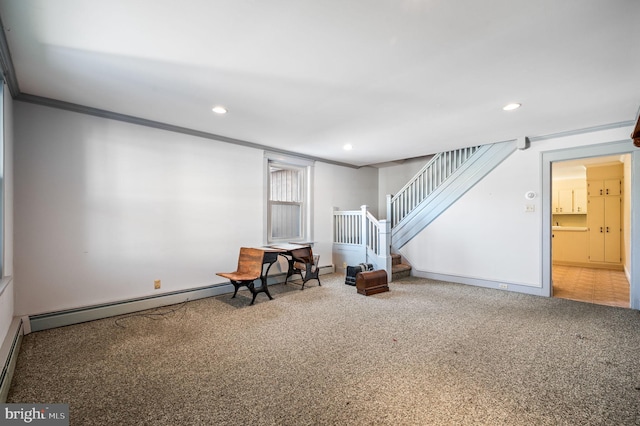 basement featuring carpet flooring, ornamental molding, and a baseboard heating unit