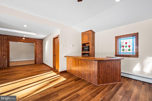 bar with dark hardwood / wood-style floors, vaulted ceiling, and brick wall