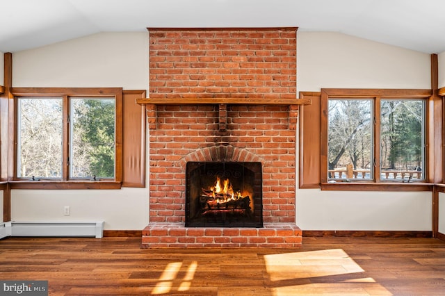 unfurnished living room with hardwood / wood-style floors, a brick fireplace, baseboard heating, and plenty of natural light