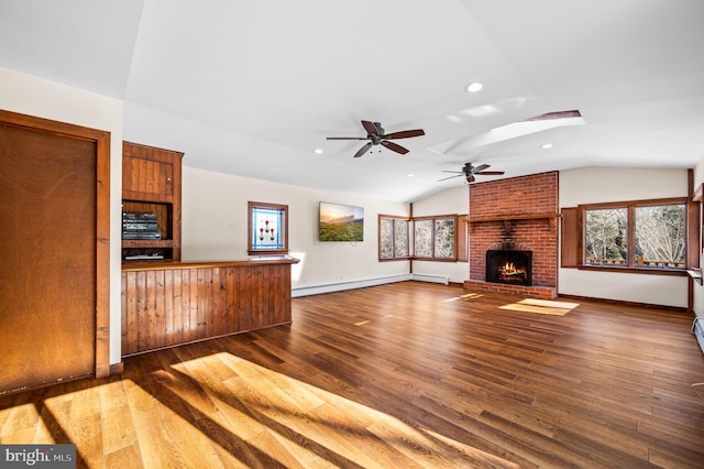 unfurnished living room featuring hardwood / wood-style flooring, ceiling fan, lofted ceiling, and a brick fireplace