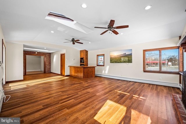 unfurnished living room with hardwood / wood-style flooring, ceiling fan, lofted ceiling with skylight, and a baseboard heating unit