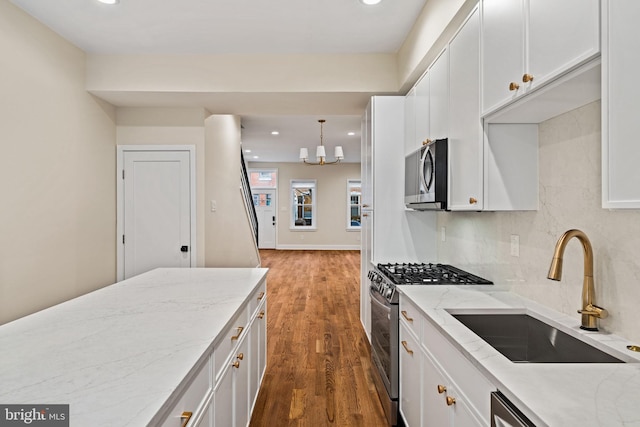 kitchen featuring white cabinetry, decorative light fixtures, dark wood-type flooring, and appliances with stainless steel finishes