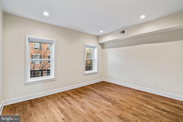 unfurnished room featuring hardwood / wood-style floors and a wealth of natural light