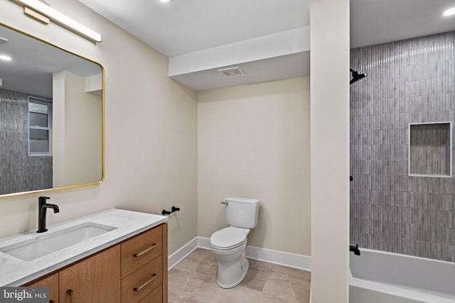 full bathroom featuring vanity, tiled shower / bath, and toilet