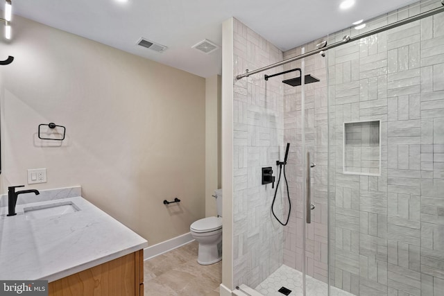 bathroom featuring vanity, an enclosed shower, and toilet