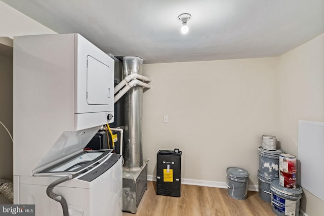 clothes washing area featuring stacked washer / drying machine and light wood-type flooring