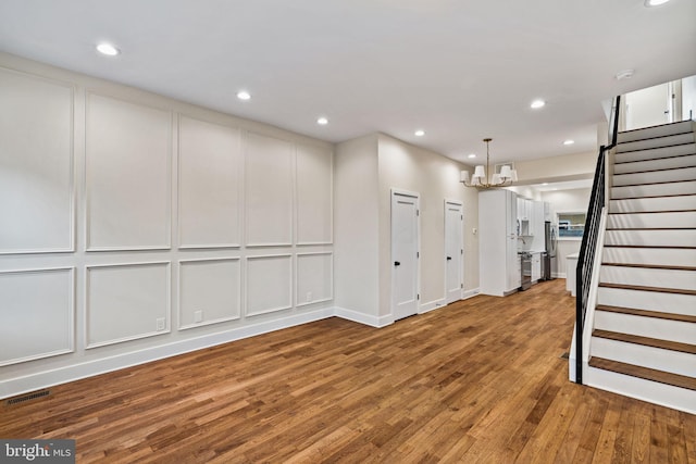 basement featuring wood-type flooring and a notable chandelier