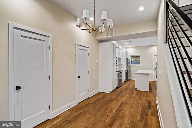 corridor featuring an inviting chandelier and dark hardwood / wood-style floors