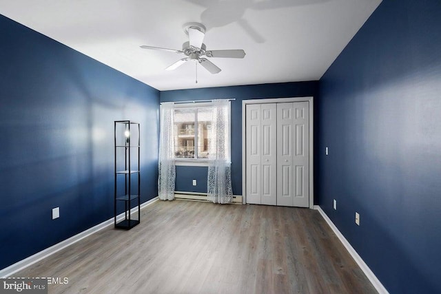 unfurnished bedroom with hardwood / wood-style floors, a closet, and ceiling fan