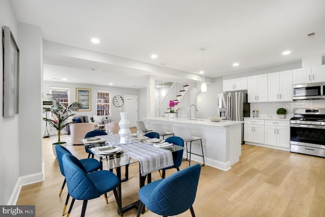 dining space with light hardwood / wood-style floors and sink