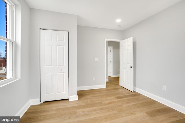 unfurnished bedroom featuring light wood-type flooring and a closet