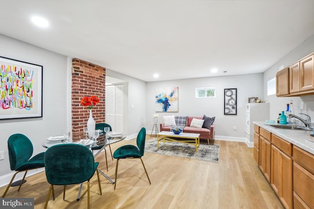 dining space with sink and light hardwood / wood-style flooring