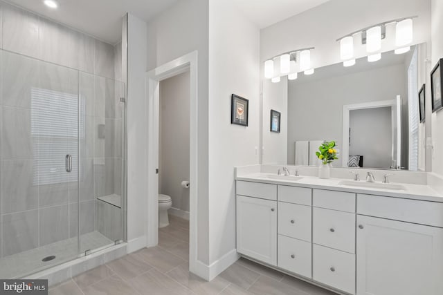 bathroom with tile patterned floors, vanity, toilet, and a shower with shower door