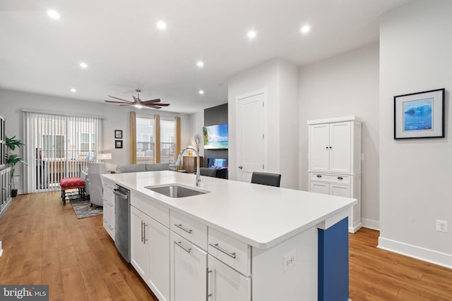 kitchen featuring sink, white cabinets, a center island with sink, and light hardwood / wood-style flooring