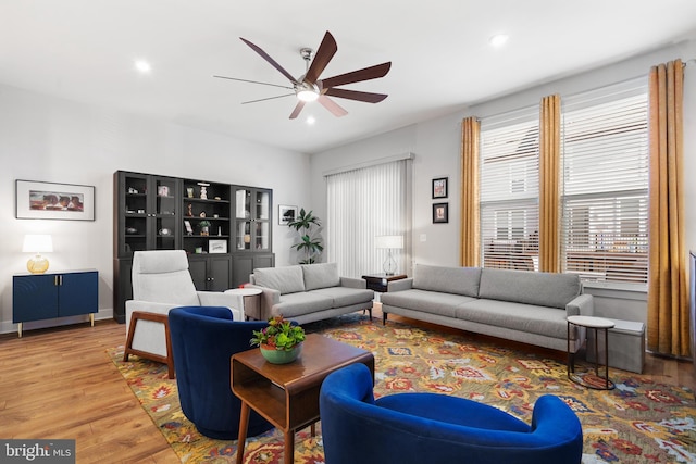 living room with ceiling fan and light wood-type flooring