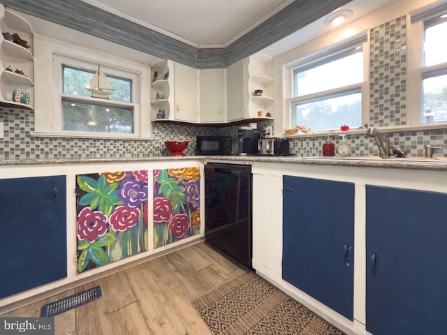 kitchen with backsplash, crown molding, black appliances, and light hardwood / wood-style floors