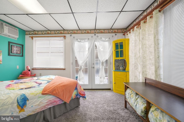 bedroom with a paneled ceiling, carpet flooring, a wall unit AC, and multiple windows