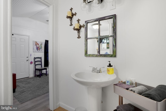 bathroom featuring hardwood / wood-style floors and vaulted ceiling