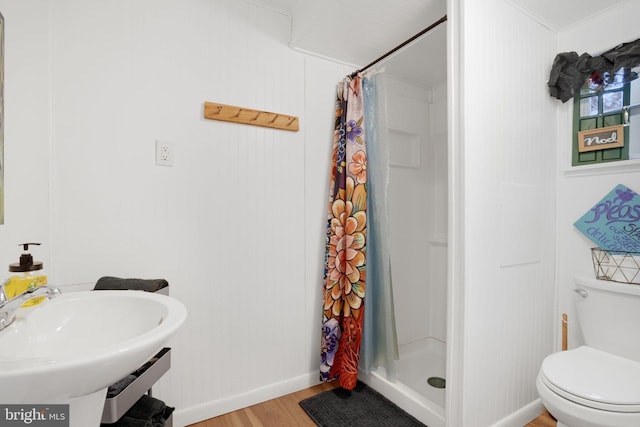 bathroom with hardwood / wood-style flooring, sink, toilet, and walk in shower