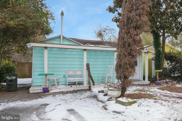 view of snow covered back of property