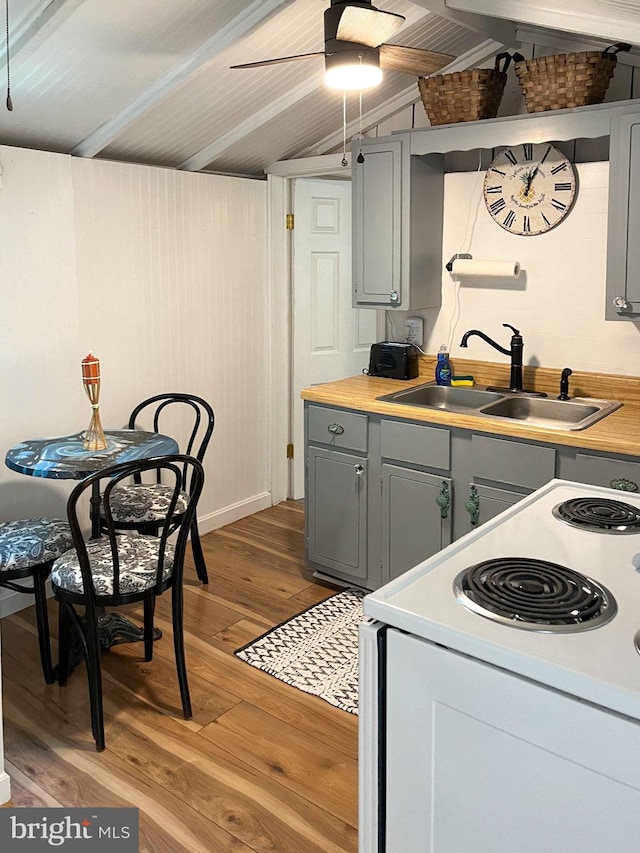 kitchen with sink, white electric range oven, light hardwood / wood-style flooring, lofted ceiling with beams, and gray cabinets