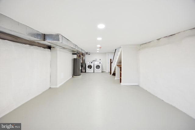 basement with water heater and washer and clothes dryer