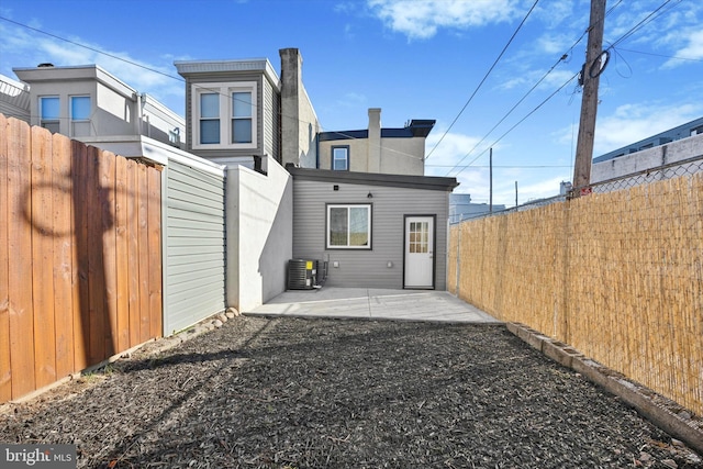 rear view of property featuring central AC unit and a patio area