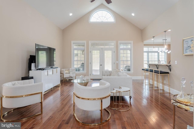 living room featuring hardwood / wood-style floors, ceiling fan with notable chandelier, a wealth of natural light, and french doors