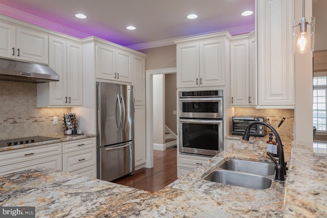 kitchen featuring hanging light fixtures, white cabinetry, sink, and stainless steel appliances