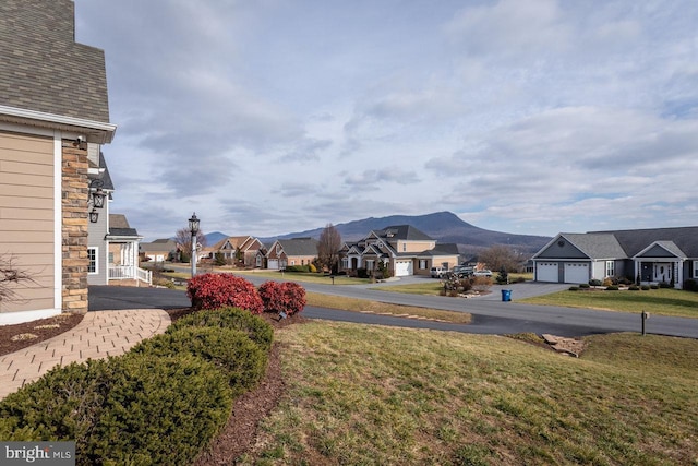 view of yard with a mountain view and a garage