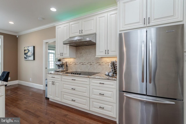 kitchen featuring stainless steel fridge, light stone counters, ornamental molding, black electric cooktop, and white cabinets