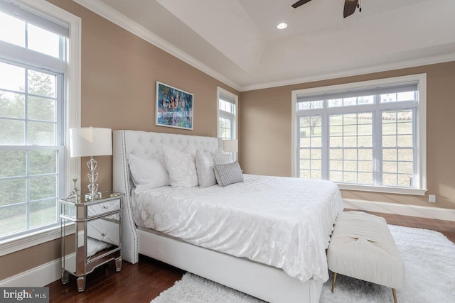 bedroom featuring a tray ceiling, ceiling fan, dark hardwood / wood-style floors, and ornamental molding