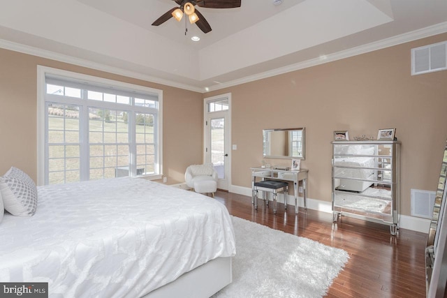 bedroom featuring a raised ceiling, ceiling fan, dark wood-type flooring, and crown molding