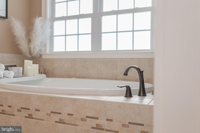 bathroom with a healthy amount of sunlight and tiled tub