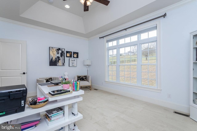 carpeted office space with ceiling fan, a raised ceiling, and ornamental molding