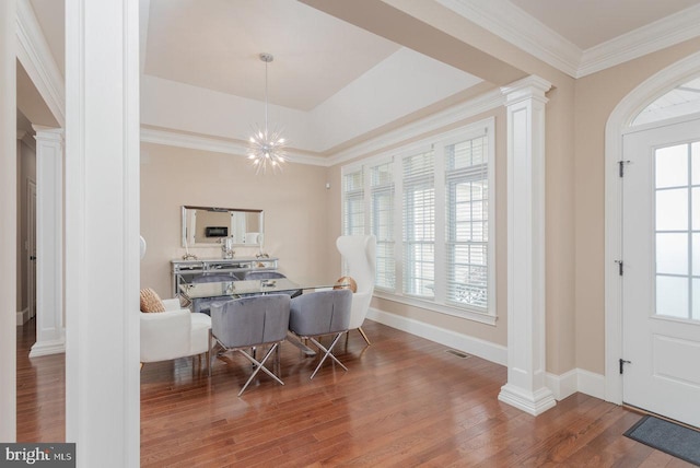 dining area with ornate columns, ornamental molding, wood-type flooring, and a notable chandelier