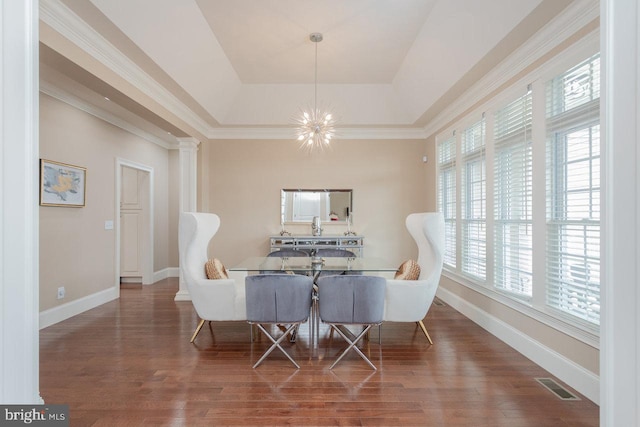 dining area featuring dark hardwood / wood-style floors, crown molding, a chandelier, and a tray ceiling