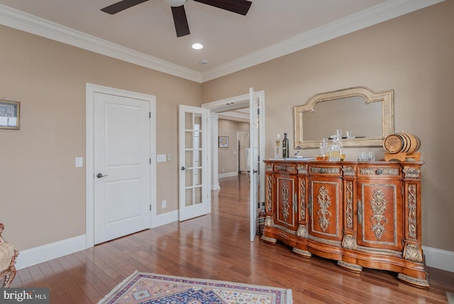 interior space with wood-type flooring, french doors, and crown molding