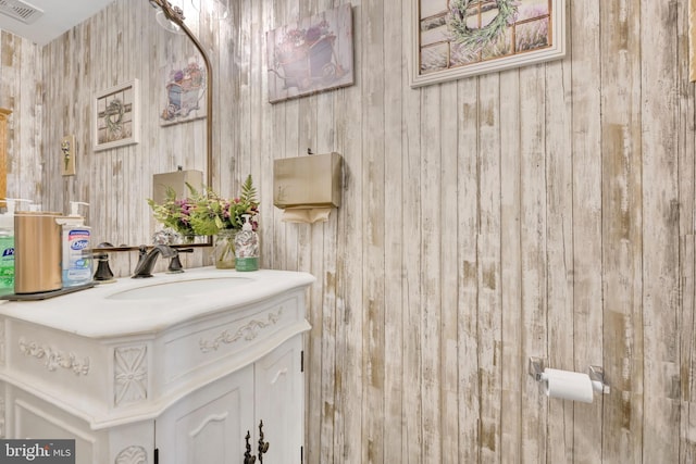 bathroom featuring vanity and wooden walls