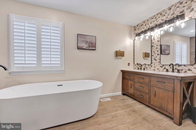 bathroom with vanity, hardwood / wood-style flooring, and a bathtub