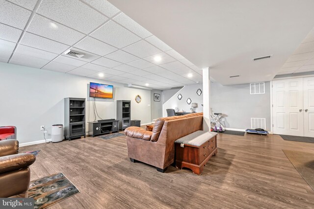 living room with hardwood / wood-style floors and a drop ceiling