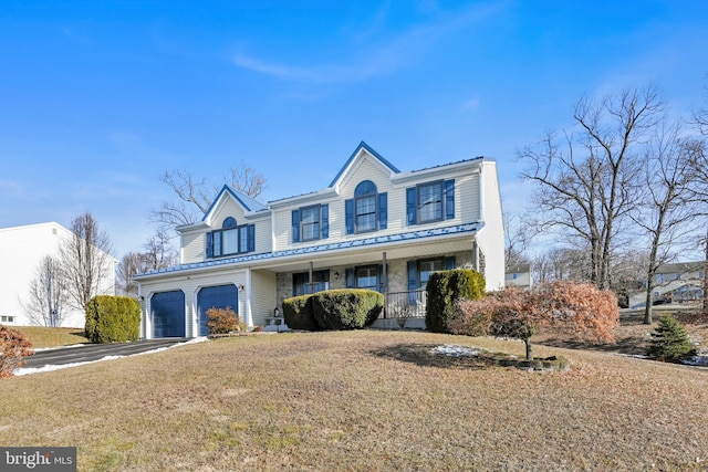 front facade featuring a front lawn, covered porch, and a garage