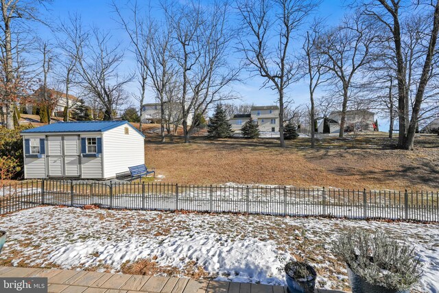 yard covered in snow featuring an outbuilding